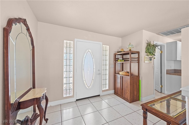 foyer entrance with visible vents, baseboards, and light tile patterned flooring