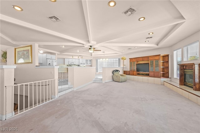 interior space with a wealth of natural light, a tile fireplace, and visible vents