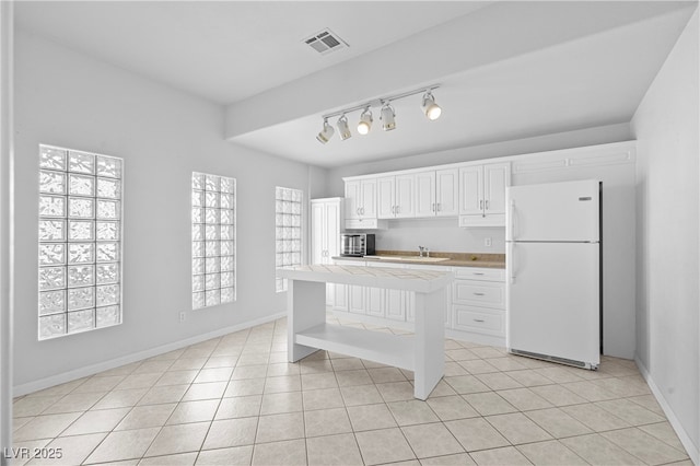 kitchen with tile countertops, open shelves, light tile patterned floors, visible vents, and freestanding refrigerator