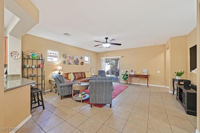 living room featuring visible vents, ceiling fan, baseboards, and light tile patterned floors