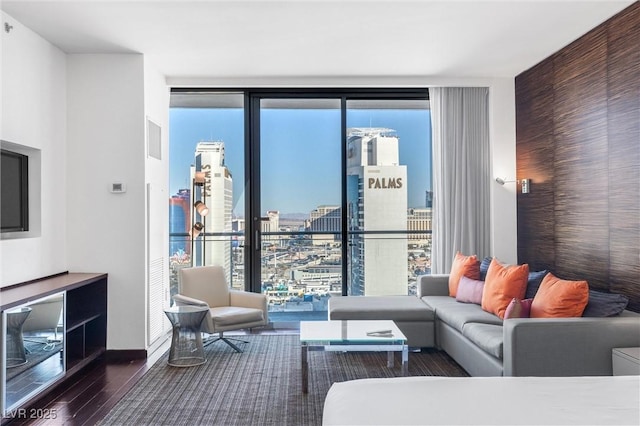 living room featuring floor to ceiling windows, wood finished floors, and baseboards