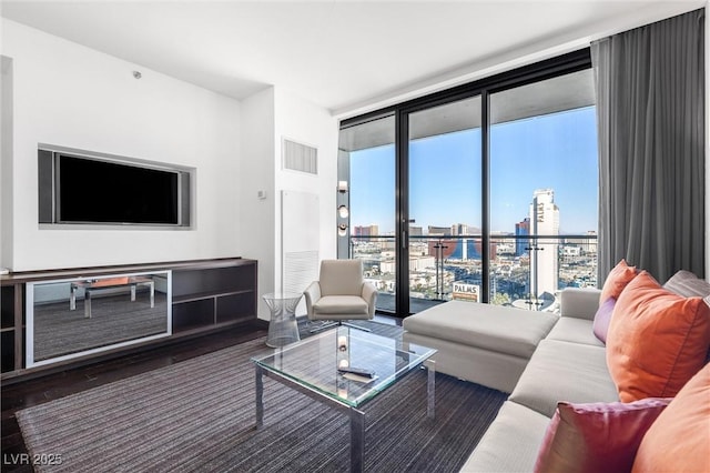 living room featuring a city view, a wall of windows, and wood finished floors
