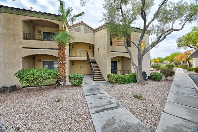 view of property featuring cooling unit and stairs