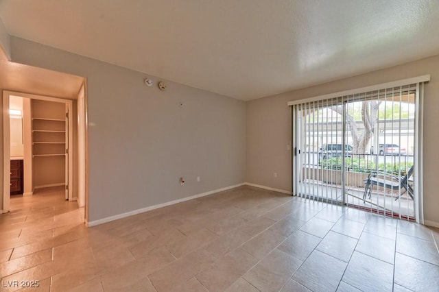 unfurnished room featuring light tile patterned floors and baseboards