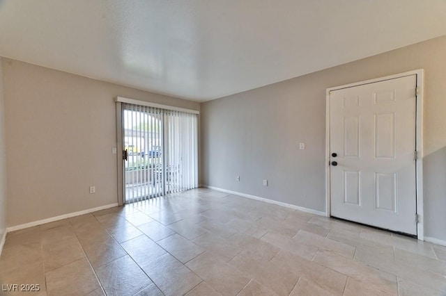 unfurnished room featuring baseboards and light tile patterned flooring