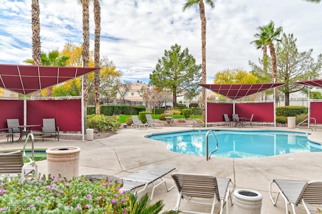 community pool featuring a patio and fence