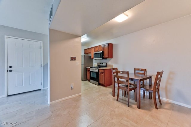 dining room featuring baseboards and light tile patterned flooring