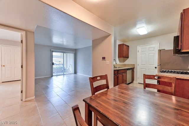 dining space featuring light tile patterned floors and baseboards