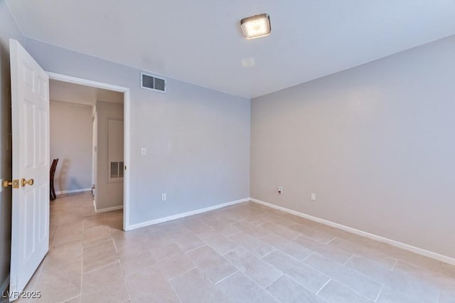 unfurnished room with visible vents, baseboards, and light tile patterned floors