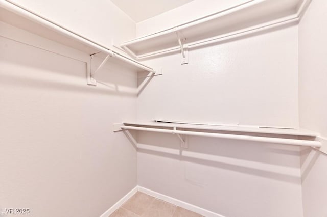 spacious closet with light tile patterned floors