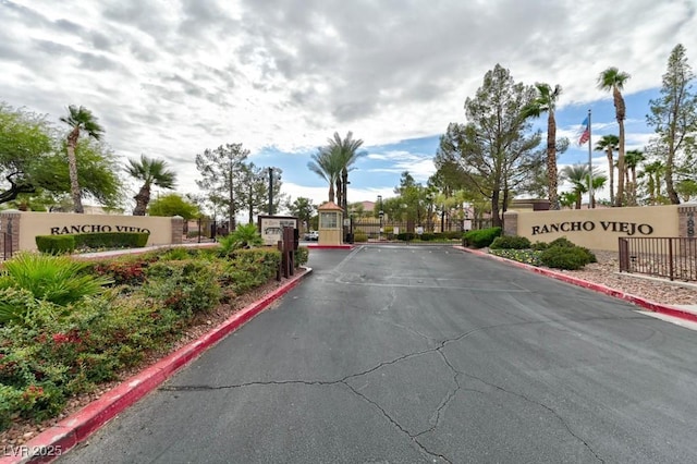 view of road with a gate, curbs, and a gated entry