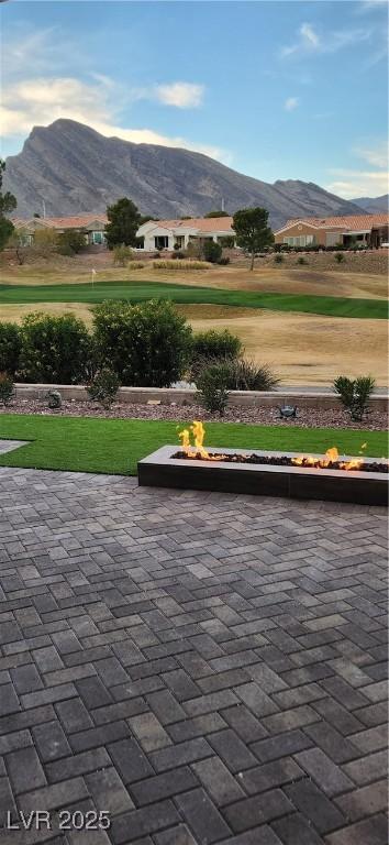 view of home's community featuring a patio area, an outdoor fire pit, a mountain view, and a yard