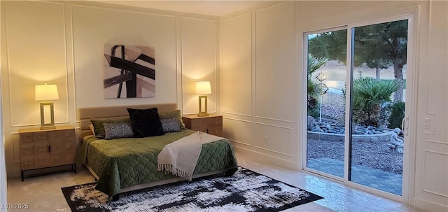 bedroom featuring access to outside and a decorative wall