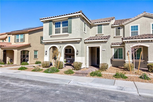 view of front of house featuring a tiled roof and stucco siding