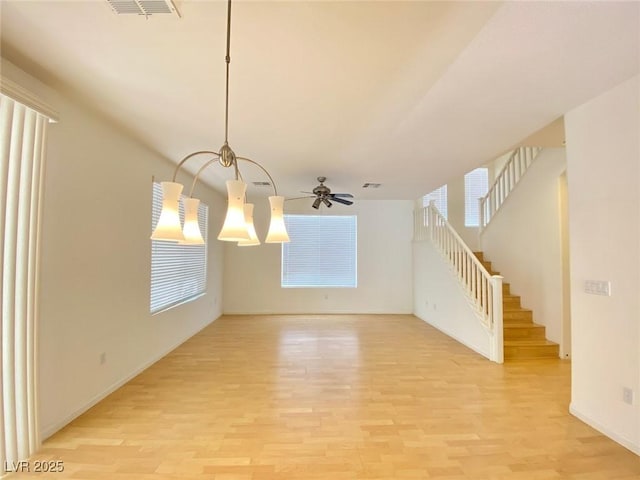 empty room with stairway, visible vents, and light wood-style floors