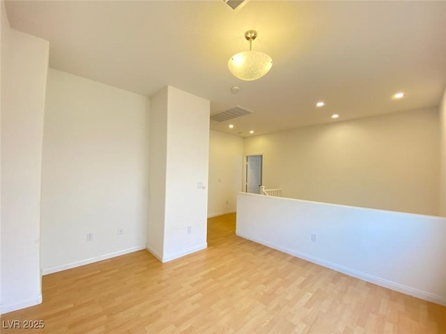 empty room with light wood-type flooring, visible vents, baseboards, and recessed lighting