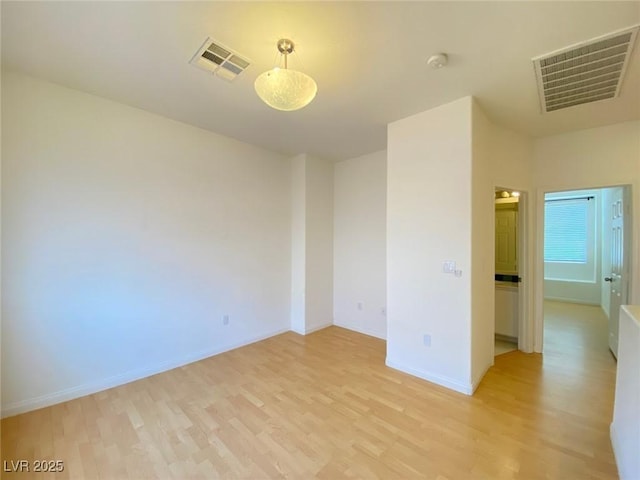 unfurnished room with baseboards, visible vents, and light wood finished floors