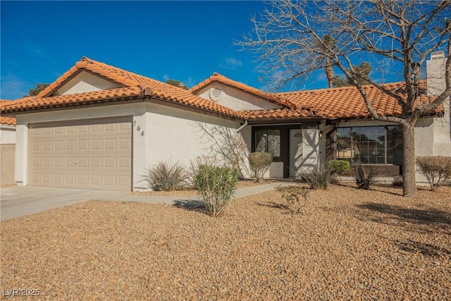 mediterranean / spanish-style house featuring a tile roof, a chimney, stucco siding, an attached garage, and driveway