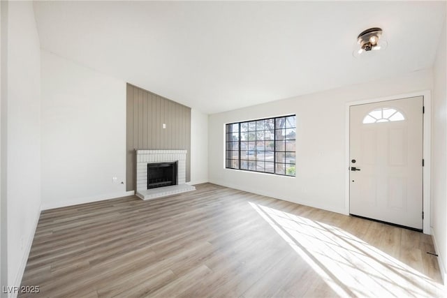 unfurnished living room featuring light wood-style floors, a fireplace, and baseboards