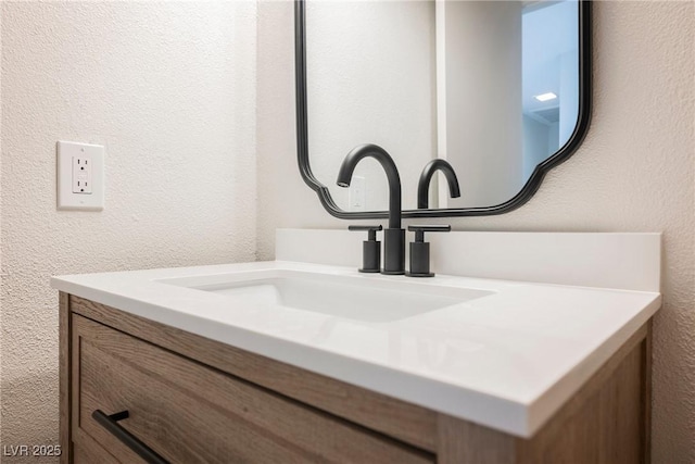 interior details featuring a textured wall and vanity