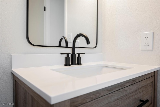 details featuring a textured wall and vanity