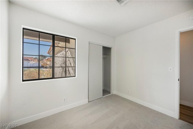 unfurnished bedroom featuring a closet, carpet flooring, and baseboards