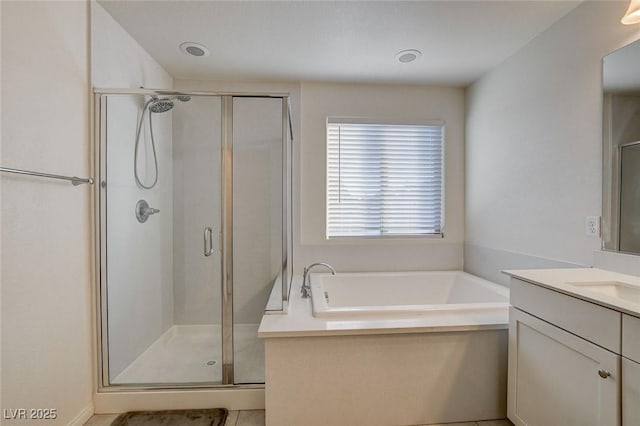 bathroom featuring vanity, a shower stall, and a bath