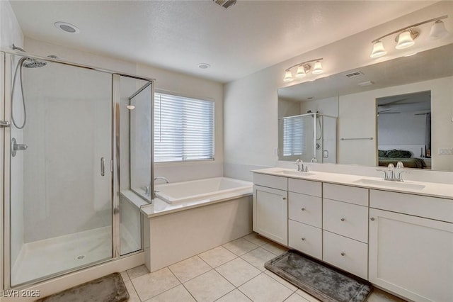 ensuite bathroom featuring double vanity, a stall shower, ensuite bath, tile patterned floors, and a sink