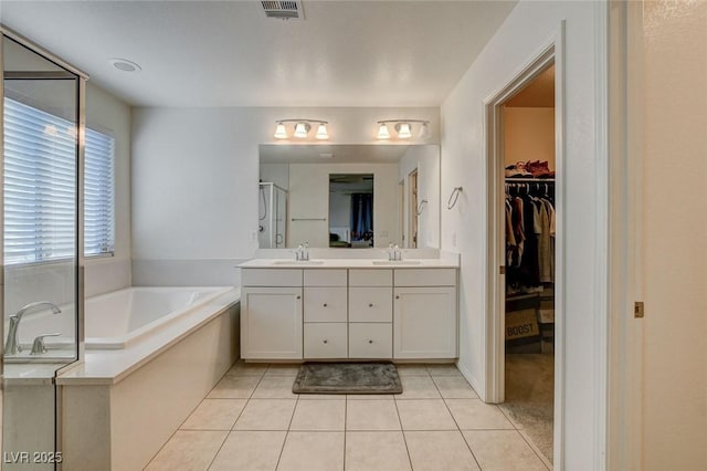 full bathroom featuring a stall shower, a garden tub, a sink, and double vanity