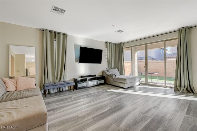 living room with light wood-type flooring and visible vents