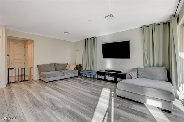 living room with light wood finished floors and visible vents