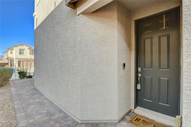 entrance to property featuring stucco siding