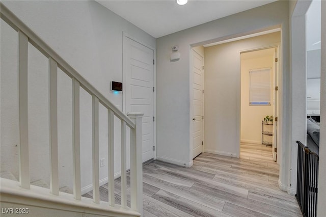 entryway featuring baseboards, stairway, and wood finished floors