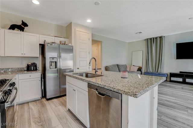 kitchen with stainless steel appliances, a sink, visible vents, and light wood-style floors