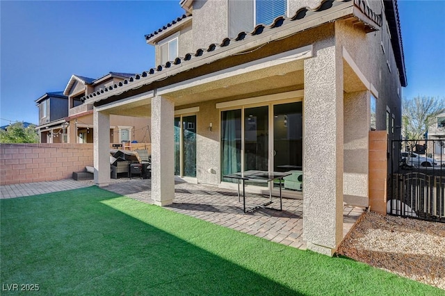 back of property with stucco siding, fence, and a patio