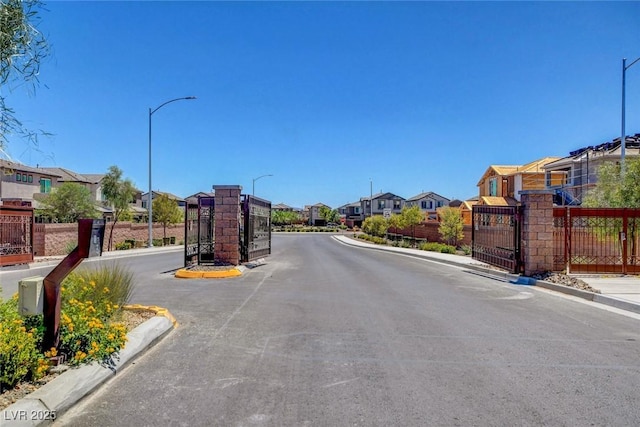 view of road with street lights, curbs, and a residential view