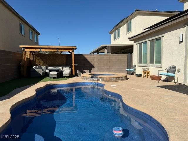 view of swimming pool featuring a patio, outdoor lounge area, a fenced backyard, and a pool with connected hot tub