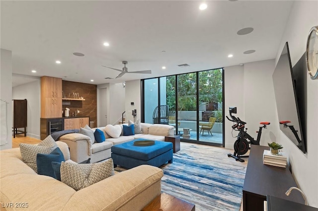 living room with recessed lighting, beverage cooler, floor to ceiling windows, baseboards, and wet bar