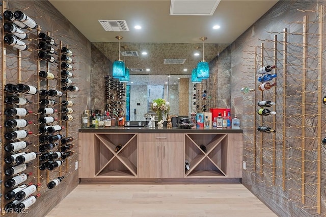 wine area featuring light wood-type flooring and visible vents