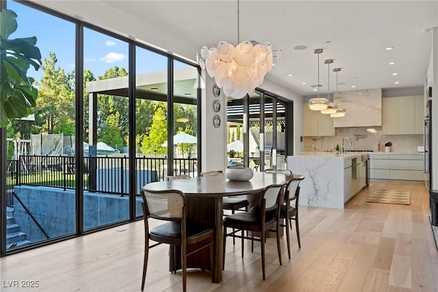 dining area featuring recessed lighting, light wood-type flooring, and a notable chandelier