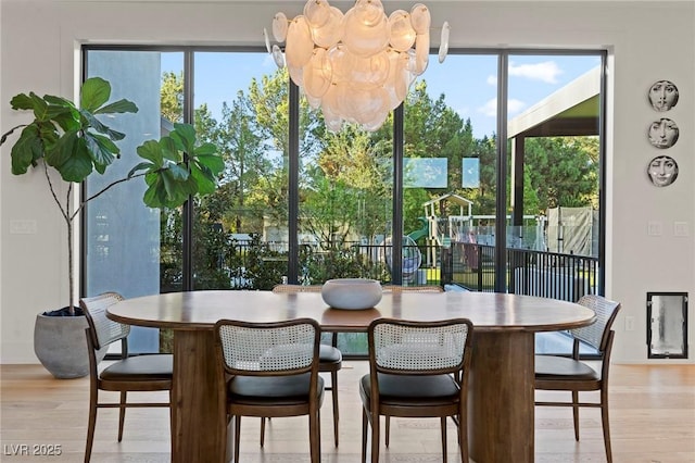 dining area featuring an inviting chandelier and light wood-style flooring