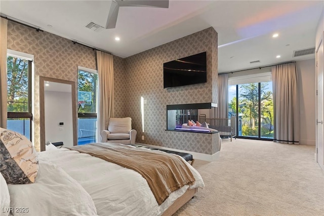 bedroom featuring wallpapered walls, visible vents, access to exterior, and a multi sided fireplace