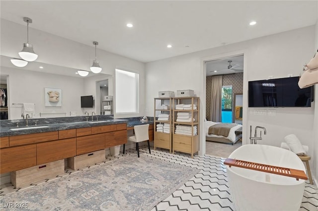 kitchen with brown cabinetry, a sink, and recessed lighting