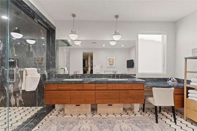 full bath featuring double vanity, a shower stall, and a sink