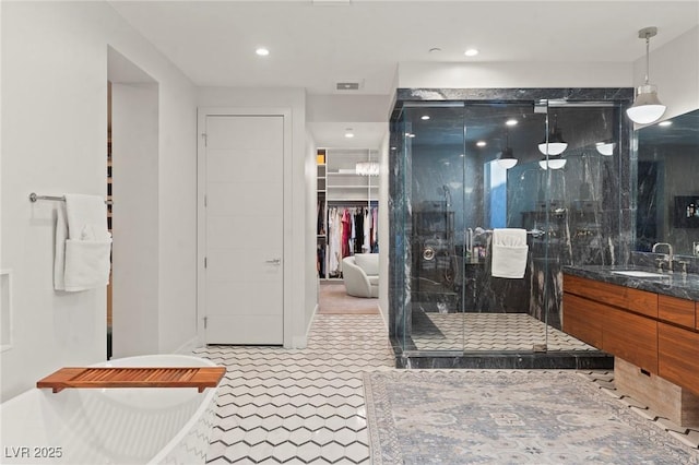 bathroom with a closet, a shower stall, vanity, and recessed lighting