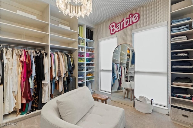 walk in closet featuring carpet floors and an inviting chandelier