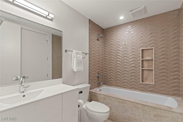 full bathroom with toilet, visible vents, tiled shower / bath, and vanity