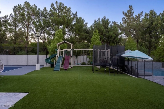 communal playground featuring fence and a lawn