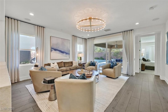 living area with baseboards, wood finished floors, visible vents, and recessed lighting