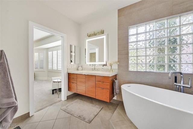 bathroom featuring tile walls, a soaking tub, vanity, and tile patterned floors